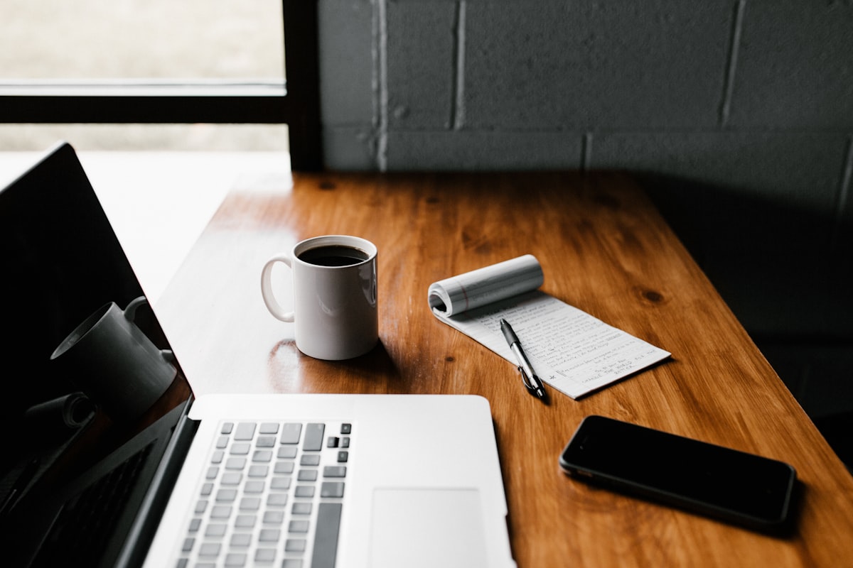 Peaceful desk by the window with notebook and coffee overlooking warm tropical surroundings